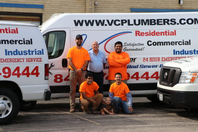 VC Plumbing's team of expert plumbers in front of their vans